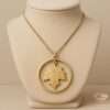 Gold maple leaf pendant inside an open circular halo on a delicate chain