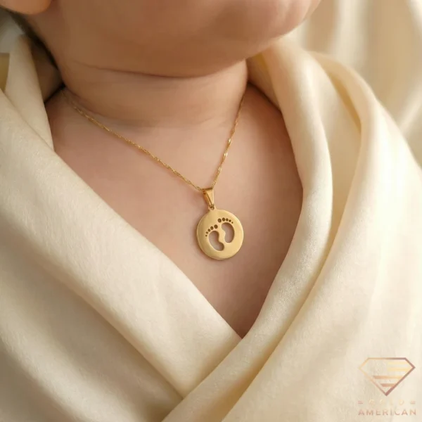 Gold Baby Footprints Medallion Necklace on Baby Close up
